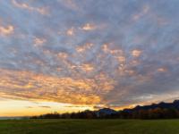Orangegelb leuchtende Fächerwolken kurz vor Sonnenaufgang